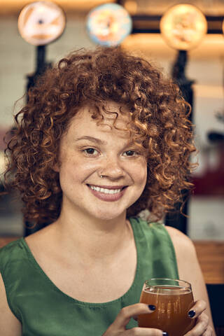 Portrait of a smiling woman in a pub having a beer stock photo