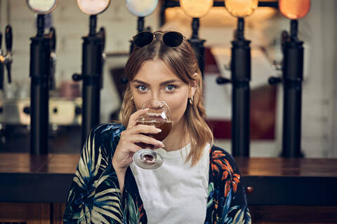 Portrait of a smiling woman in a pub having a beer stock photo
