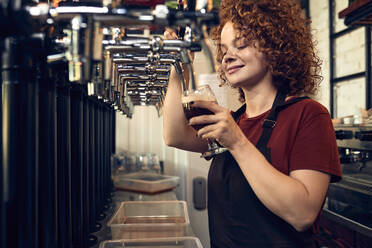 Barkeeperin zapft Bier in einer Kneipe - ZEDF03691