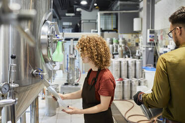 Mann und Frau arbeiten in einer Handwerksbrauerei - ZEDF03694