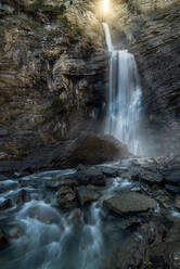 Scenic unglaublichen Blick auf kleine Berg kalten Wasserfall fließt durch verschneite Felsen - ADSF12633