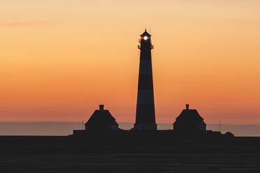 Deutschland, Schleswig-Holstein, Westerhever, Silhouette des Leuchtturms Westerheversand bei stimmungsvoller Dämmerung - KEBF01620