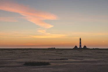 Deutschland, Schleswig-Holstein, Westerhever, Sandstrand in der Morgendämmerung mit Leuchtturm Westerheversand im Hintergrund - KEBF01621