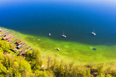 Drohnenansicht von Segelbooten und Bootshäusern am grünen Ufer des Starnberger Sees im Frühling - SIEF10010