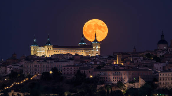 Wunderschöne Kulisse der beleuchteten alten Palast über der Stadt in bunten Nacht mit voller roter Mond in Toledo gebaut - ADSF12644