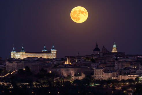 Wunderschöne Kulisse der beleuchteten alten Palast über der Stadt in bunten Nacht mit voller roter Mond in Toledo gebaut - ADSF12648