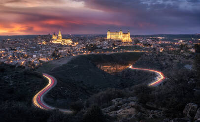 Erstaunliche Drohne Blick auf alte Stadt mit alten Gebäuden leuchtenden während des Sonnenuntergangs und leuchtende Autobahn in langen Belichtung - ADSF12682