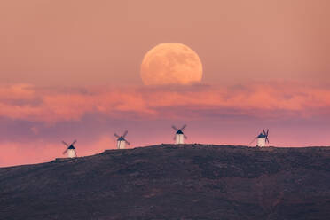 Erstaunliche Landschaft der majestätischen Vollmond über Tal mit Windmühlen in Sonnenuntergang - ADSF12736