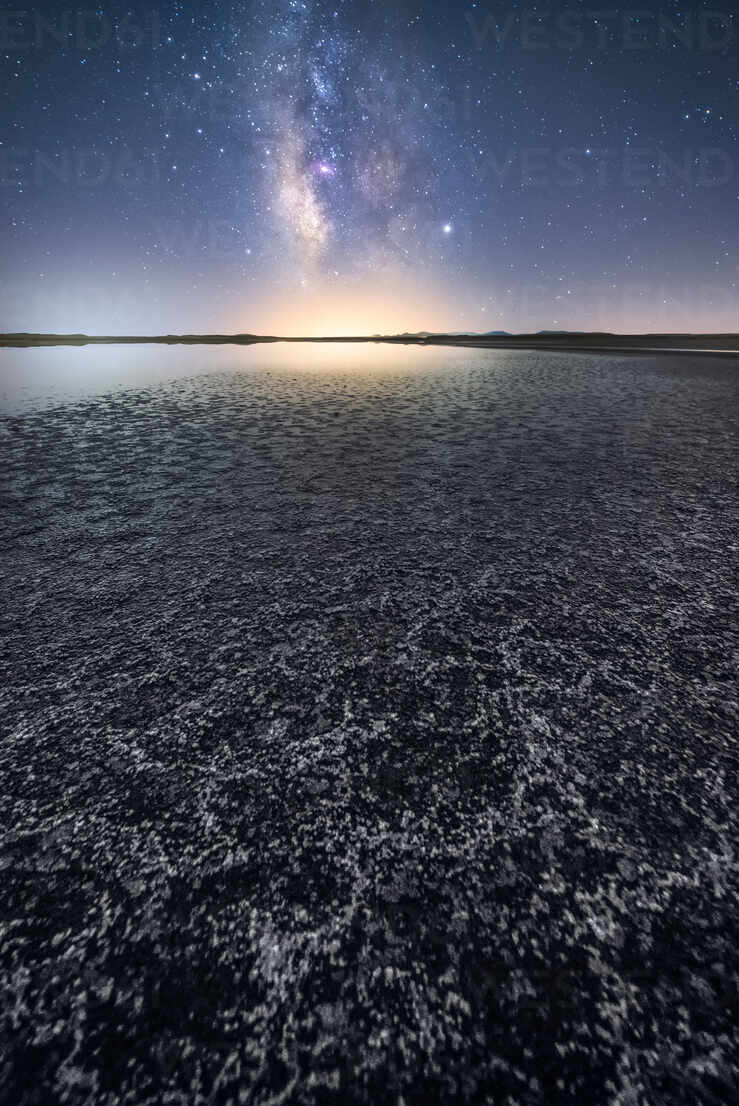 Empty trockenen Boden unter ruhigen Wasser unter bunten nächtlichen Himmel  mit Milchstraße auf dem Hintergrund, lizenzfreies Stockfoto