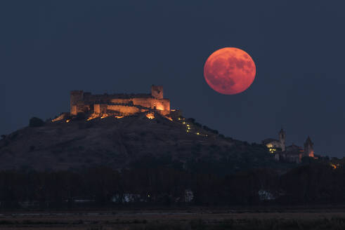 Wunderschöne Kulisse der beleuchteten alten Palast über der Stadt in bunten Nacht mit voller roter Mond in Toledo gebaut - ADSF12767