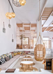 Gemütliches Wohnzimmer mit Holzmöbeln und weißen Wänden mit geometrischen Verzierungen - ADSF12896