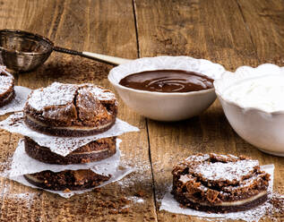 Round freshly baked brownies on table with bowls of chocolate and butter - ADSF12941