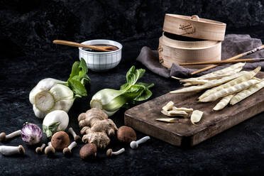 Layout der sortierten frisches Gemüse und Gewürze für Dim Sum Ramen mit Sojasauce auf schwarzem Hintergrund - ADSF12956