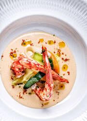 Draufsicht auf eine schmackhafte Suppe mit Knoblauch und frischem Gemüse, garniert mit Krabbenscheren in einem teuren Restaurant - ADSF12960