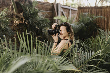 Female photographer photographing palm trees - SMSF00163