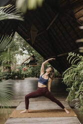 Woman practicing warrior pose II - SMSF00185