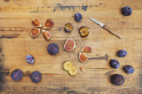 Freshly harvested figs and plums on wooden surface stock photo