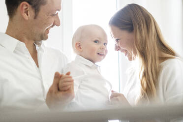 Fröhliche Eltern, die mit ihrem Baby zu Hause spielen - SAJF00093