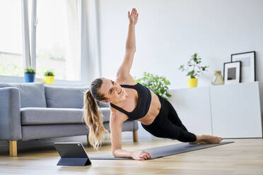 Frau macht seitliche Plank-Übung im Wohnzimmer zu Hause - BSZF01658