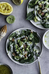 Von oben appetitlicher gesunder Lachssalat mit Grünzeug und geschnittener Zitrone auf dem gedeckten Tisch - ADSF13124