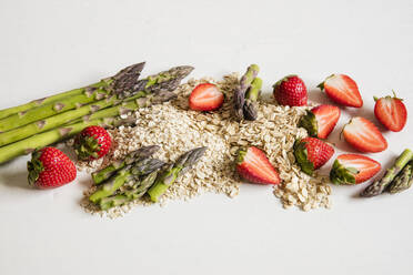 Studio shot of oats, asparagus stalks and halved strawberries - EVGF03715