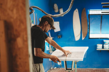 Handwerker bei der Herstellung eines Surfbretts in der Werkstatt - ADSF13139