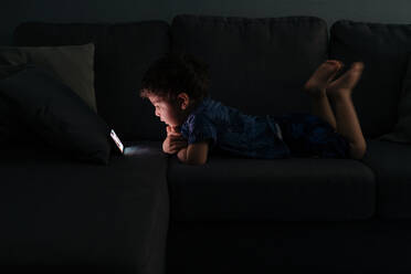 Curious little boy browsing smartphone at home - ADSF13159