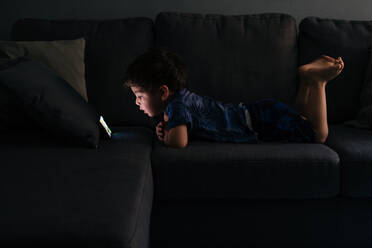 Curious little boy browsing smartphone at home - ADSF13160
