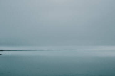 Friedliche Landschaft von ruhigen Meer Treffen grauen bewölkten Himmel auf Wintertag in Island - ADSF13272