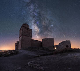 Castle on rough rocky mountain under spectacular scenery with luminous sky and Milky Way - ADSF13291