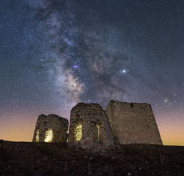 Burg auf einem schroffen Felsen vor spektakulärer Kulisse mit leuchtendem Himmel und Milchstraße - ADSF13292