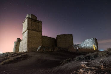 Burg auf rauem Felsenberg vor spektakulärer Kulisse mit leuchtendem Sternenhimmel - ADSF13293