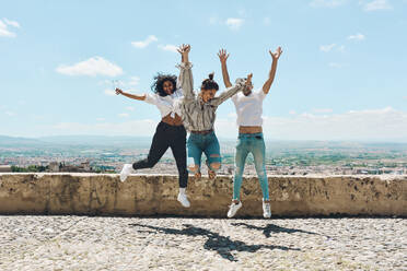 Eine Gruppe von Freunden, die in Spanien Urlaub machen und den Panoramablick auf die Alhambra in Granada bewundern - ADSF13434