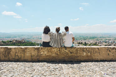 Eine Gruppe von Freunden, die in Spanien Urlaub machen und den Panoramablick auf die Alhambra in Granada bewundern - ADSF13436