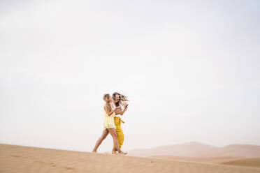 Fröhlich stilvolle zwei blonde Frauen Freunde mit Handy beim Wandern in der Wüste von Marokko - ADSF13469