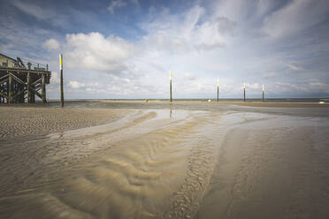 Deutschland, Schleswig-Holstein, Sankt Peter-Ording, Pfähle am Sandstrand der Küste - ASCF01419