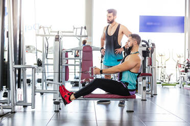 Erwachsener muskulöser Sportler bei einer Übung im Fitnessstudio - ADSF13505