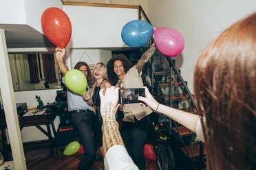 Woman photographing friends dancing during party at home - MEUF02027