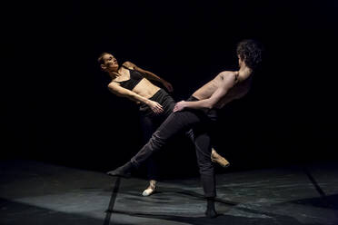 Tänzer und Tänzerin beim zeitgenössischen Ballett auf schwarzer Bühne - NGF00619