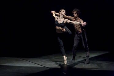 Male and femal dancer performing contemporary ballet on black stage - NGF00620