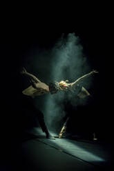 Tänzer und Tänzerin beim zeitgenössischen Ballett auf schwarzer Bühne - NGF00632