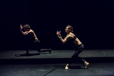 Male and femal dancer performing contemporary ballet on black stage - NGF00633