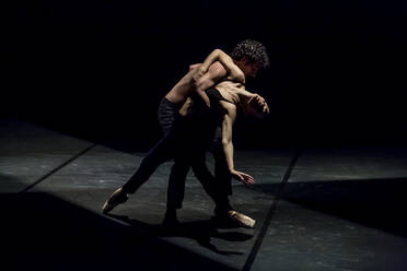 Tänzer und Tänzerin beim zeitgenössischen Ballett auf schwarzer Bühne - NGF00634