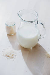 Glas mit Milch und Reis auf dem Tisch - ADSF13727
