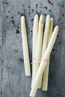 Studio shot of peppercorns and bundle of peeled white asparagus - ASF06669