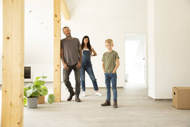 Familie steht auf dem Hartholzboden im Dachgeschoss des neuen Hauses - MJFKF00607