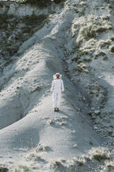 Man wearing a beekeeper dress in a dry apocalyptical landscape - AFVF07068