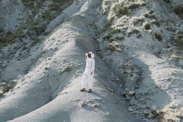 Man wearing a beekeeper dress in a dry apocalyptical landscape - AFVF07069