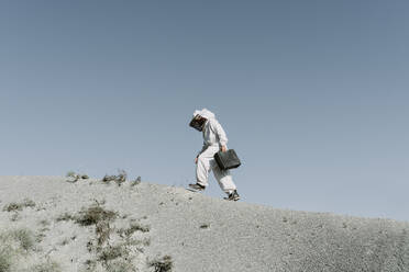 Mann mit Aktentasche und Imkerkleid in einer trockenen apokalyptischen Landschaft - AFVF07095