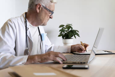 Oberarzt arbeitet am Laptop in seiner Klinik - AFVF07108